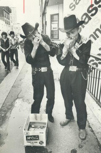 Yonge music: Tex Slater (left) and Tex Payne concentrate on what they call the basic music, offering harmonica renditions of Red River Valley and Wabash Cannon ball