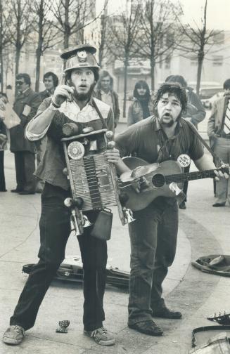 Minstrels. Washboard Hank and Reverend Ken (as they call themselves), of Peterborough, mad a hit with the folks outside the Eaton Centre yesterday. A (...)