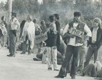 Moving out of mosport at the end of the Strawberry Fields rock festival, young hitchhikers stand beside the highway holding up signs indicating where (...)
