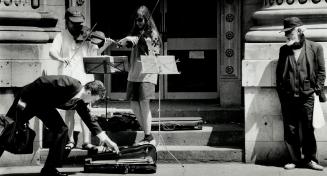 Fiddlers on The Hoof. Violinists Anne Kim, left, and amd Dini Odynski spend a couple of hours every day entertaining the lunchhour crowds on Yonge St.(...)