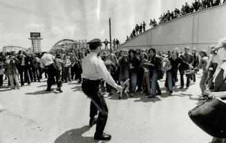 Bracing themselves in defensive stance, police prepare to hold back any charge by scores of gate-crashes at the pop festival. Some of the rock fans sh(...)
