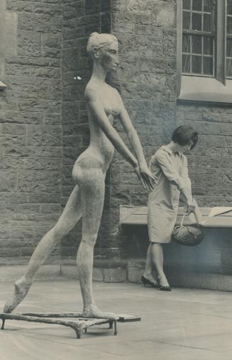 Summer student Claudette Therrien, taking English, is seen beside statue The Dancer, work of artist Thomas Bowie