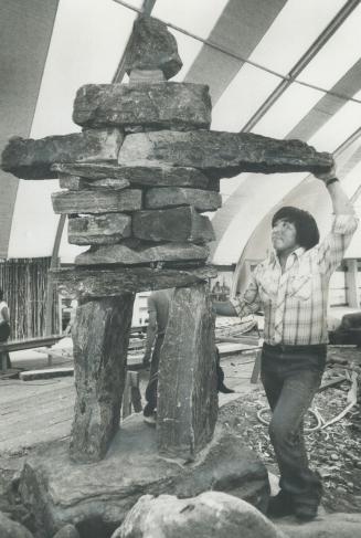 Rock-shaped man in the Native Heritage Show at the Ontario Science Centre gets sized up by sculptor Joanasi Jack
