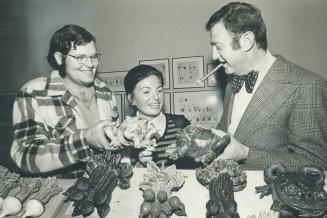 Artist David Gilhooly, left, shows his ceramic frogs and vegetables to Elizabeth Kady and John Zeldin at the art exhibit put together by the art renta(...)