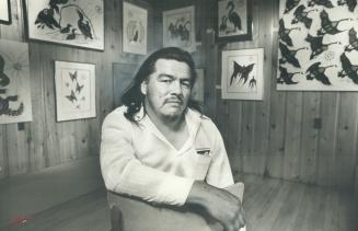 Indian artist Norman Knott, 33, one of Canada's best-know, visits Curve Lake Reserve art gallery where some of his works are displayed behind him. His(...)