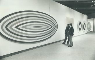 Two visitors to the Zacks Gallery of the Art Gallery of Ontario admire painting from selection of Claude Tousignant works
