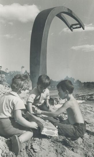 Children of the working sculptors at High Park enjoy themselves in their improvised sandbox beside the unfinished creation by Len Lyle of New Zealand.(...)