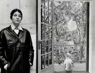 Christiane pflug stands in front of a painting she did sitting son a kitchen stool and looking out the back door of her Woodlawn Ave home. The realism(...)