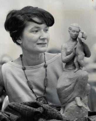 Art by women to Aid St. Lawrence. Artist Anne Proulx holds sculpture by Pauline Fediow