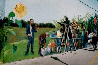 Down on the farm on front St. Artist Joseph Stickley puts some leafy touches yesterday on his mural on Front St. side of the north building of St. Law(...)