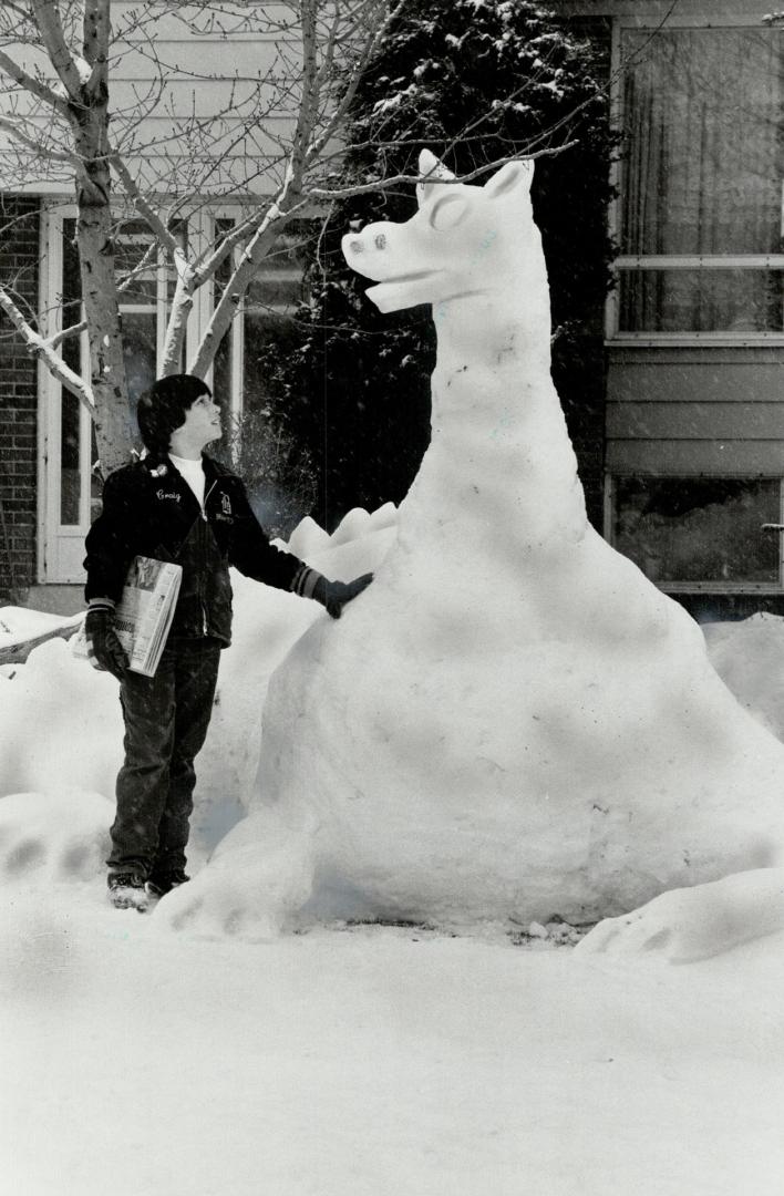 Here today . . .: Craig Francis examines a snow sculpture of Puff the Magic Dragon on the lawn of Craig's Brampton home. Puff might not really be magi(...)