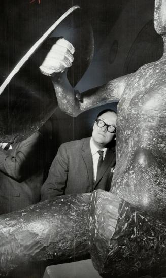 Massive sculpture at last night's showing of Henry Moore work gets inspection from Sir Hugh Casson, the internationally known British architect who officially opened the exhibition