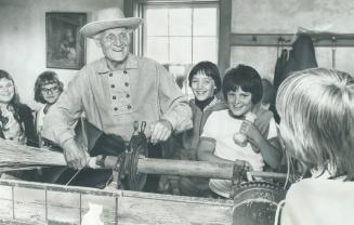 Special Host Ed Plant, 69, shows schoolchildren at Black Creek Pioneer Village how to make brooms on an antique machine
