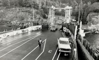 Worker directs where vehicles are to go as ferry loads at Otter Bay, Pender Island