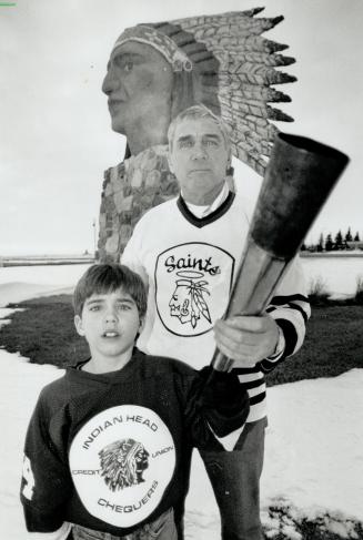 Lighting the way: Winter games torch bearers Fred Brown, 56 and grandson Aaron, 7 stand in front of a sculpture that symbolizes the town of Indian Head