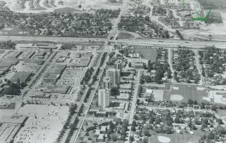 Aerial View: Harwood Ave. runs down the middle of this photo of Ajax's downtown area. Highrises and shopping centres line the main street. Highway 401(...)