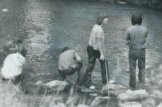 Mary Tighe, a sociology major, tries her luck at fishing with some of the boys at Pine Ridge School