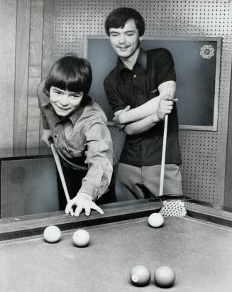 Two of the boys relax after school by playing billiards in one of the recreation rooms of the Barrie house