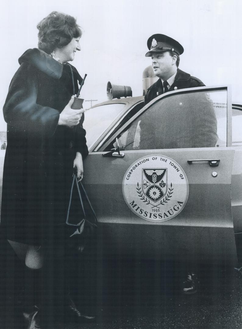 Work, Policewoman Maureen Grant checks with Mississauga police Constable Bill Sholin at door of his Most of her time is spent working with youths. [Incomplete]