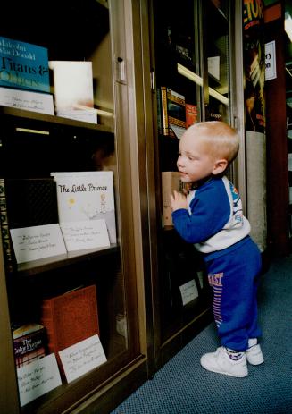 Taking a peek: Mark Tuer, 20 months old, checks out the collection of favorite books donated by famous Canadians to Mississauga's new Central Library