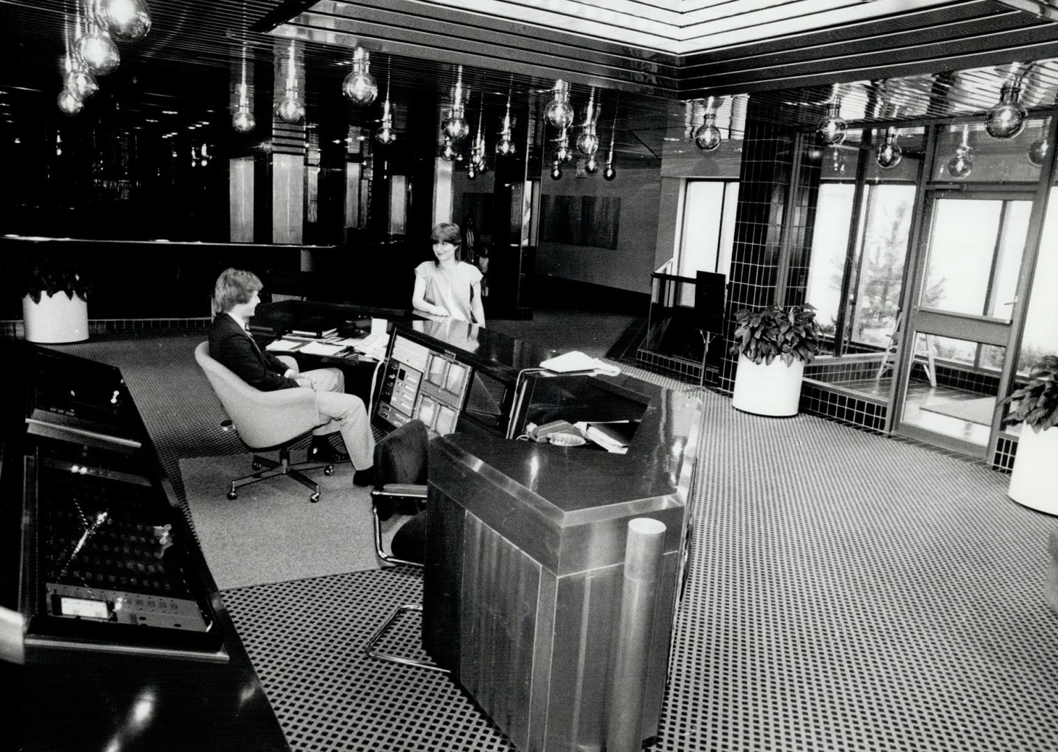 On watch: Security guard keeps an eye on the TV monitors in the spectacular lobby of Manhattan Place