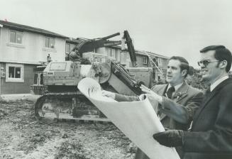 Rapid Growth of the residential area of the Town of Pickering is being observed here by Mayor George Ashe, left, and the town's administrative clerk, (...)
