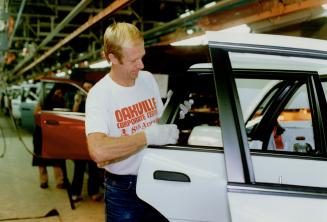 On the Line: Times will get tougher for young workers, says Ken Robertson, putting on a molding at the Oakville Ford Plant