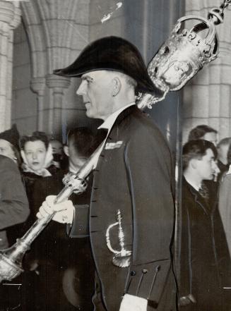 Sergeant-at-arms, Lieut.-Col. W. J. Franklin, carries the mace as he heads procession of members of parliament into Senate to hear the throne speech