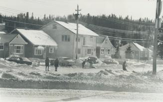 Wawa's snow - covered main street, where idle miners walk aimlessly, killing time