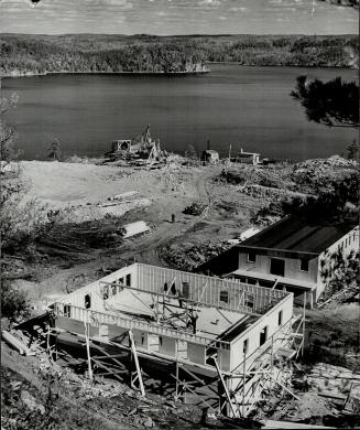 Two mine buildings under construction in foreground, with view of shaft site and surface buildings at Steep Rock Mines, 135 miles west of Ft. William