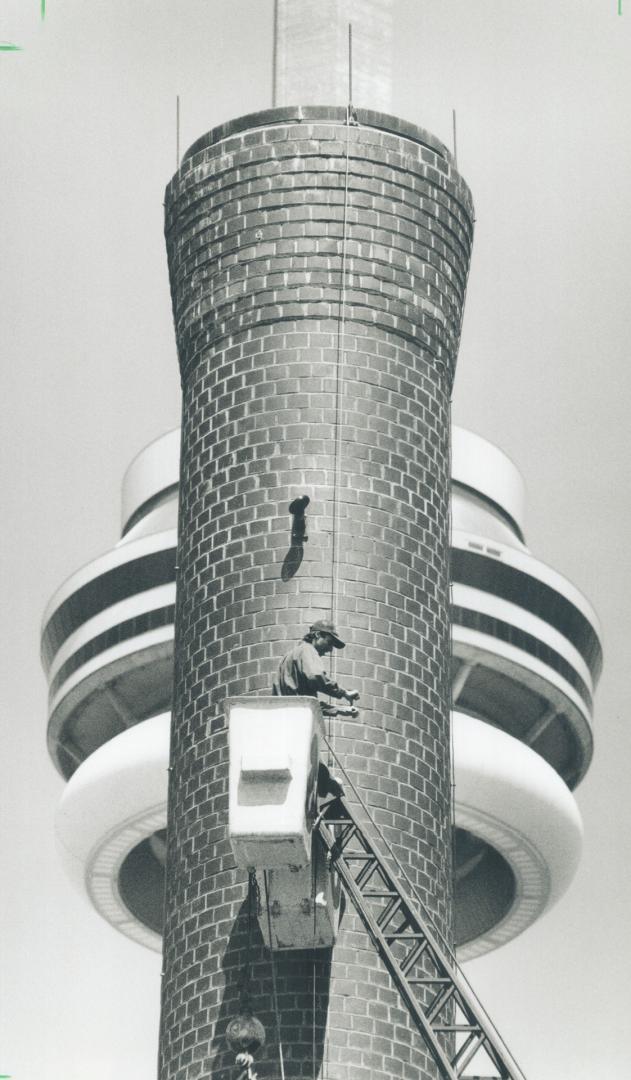 Two Towers, With the CN Tower looming in the background, ironworker John Wells attaches construction lights to the power plant smokestack at Harbourfr(...)