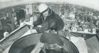 On top of the old Bank of Commerce Building-now to be called Commerce Court North-is sheet metal worker Steve Horvath