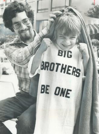 Warming up for a festival, Wearing a Big Brother T-shirt to get warm after a swim, 8-year-old Colin Harrison of Toronto lets his Big Brother, Mike Dorfman of Whitby, dry his hair