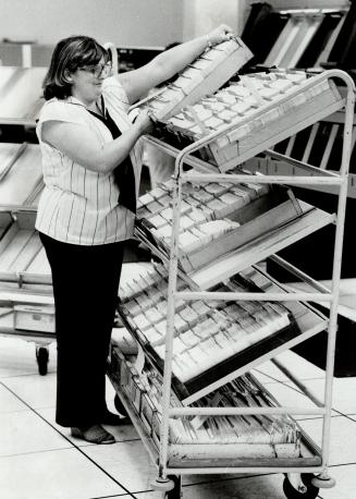Collecting: Elaine Robins gathers cheques into large trays holding about 3,000 pieces of paper each