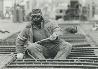 Cold comfort. Toronto Harbour Commission worker John Magee was bundled up yesterday while repairing the Cherry Street bridge grating. Icy wind from th(...)