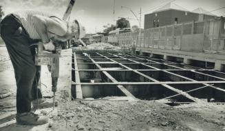 Bridge to nowhere. Repairs to the Gerrard St. E. bridge over the Don Valley Parkway continue as construction worker Bruce McGee of Peter Kiewit Sons C(...)