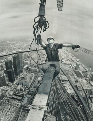 Sitting on top of Toronto. Perched 1,470 feet above Toronto and 27 feet out from the growing CN Tower, iron worker Larry Porter pulls at the hook of a(...)
