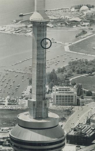 Cleaning up -- and up. Few people disturb Tony Tracy (circled) as he cleans the concrete on the 1,815-foot-high CN Tower yesterday. He's at about 1,40(...)