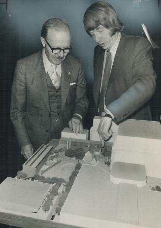 Rev. James Fisk of Holy Trinity Church looks over new model of Eaton Centre development with Mayor William Dennison. Builder of the development agreed(...)