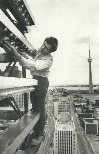 Watt's up? Alex Prosser, Canada Life electrician, spends part of his time making sure the 1,500 long-life 40 watt bulbs on the building's weather beac(...)