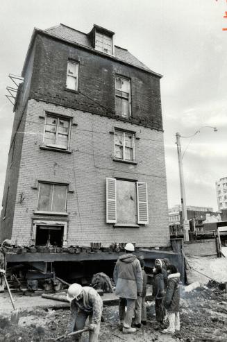Downtown youngsters take an interest in the moving of Scadding House to its new site in Trinity Square where it will be part of Eaton's City Centre. T(...)