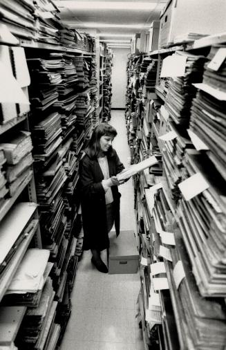 Heartbeat of Past: Clerk Cathy Cullen retrieves tax records from the collection, which includes maps, wills, diaries - even home movies of yesterday's family life