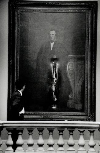 Gashed Portrait: An Osgoode Hall usher examines a painting of Ontario's chief justice from 1884 to 1897, Sir John Hawkins Hagarty, one of 7 vandalized there Tuesday