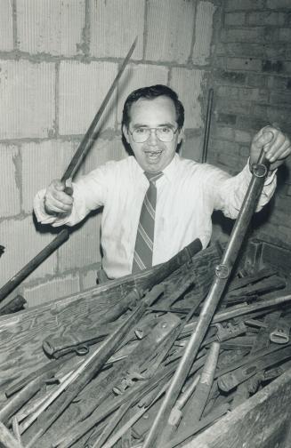 Modern swashbuckler: Juan Ross, contract inspector for the province, tunes up his swashbuckling skills with bayonets found in the ceiling of a basement room being renovated at Queen's Park