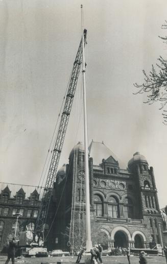 New pole for a new flag, A derrick raises the new 136-foot pole which will fly Canada's Maple Leaf flag into position to the west of the main Queen's Park entrance today