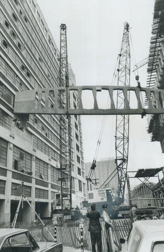 Laying A Sidewalk--4 Storeys High, First of two 85-foot, 90-ton spans for a pedestrian walkway between the fourth floors of Simpsons-Sears mail order (...)