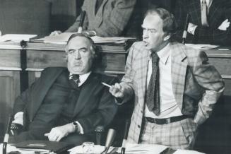 Answering a question, Health Minister Frank Miller gestures yesterday in the Legislature while Transportation Minister James Snow sits beside him. In (...)