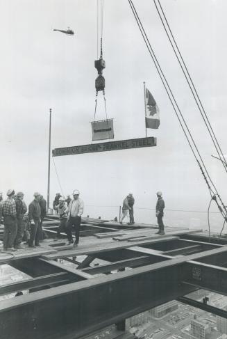 The Big moment arrives as the last beam, sporting a Maple Leaf flag, is lowered into place
