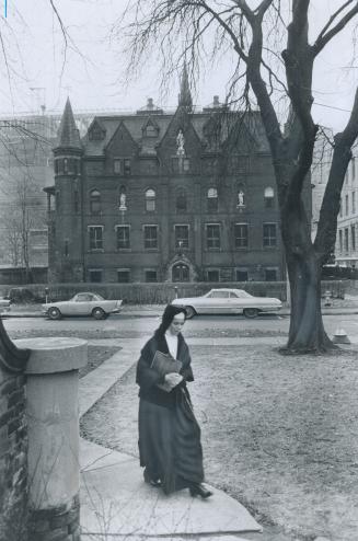 Grim Old Convent on St. Joseph St. will have serenity shattered by wreckers, A Sister of St. Joseph walks by the structure which, for nearly 100 years, has sheltered Precious Blood nuns