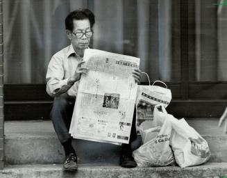 What's new in the world? Time out from a busy day fo shopping takes the form of a quiet step to sit on and a newspaper to read for this man, who was o(...)